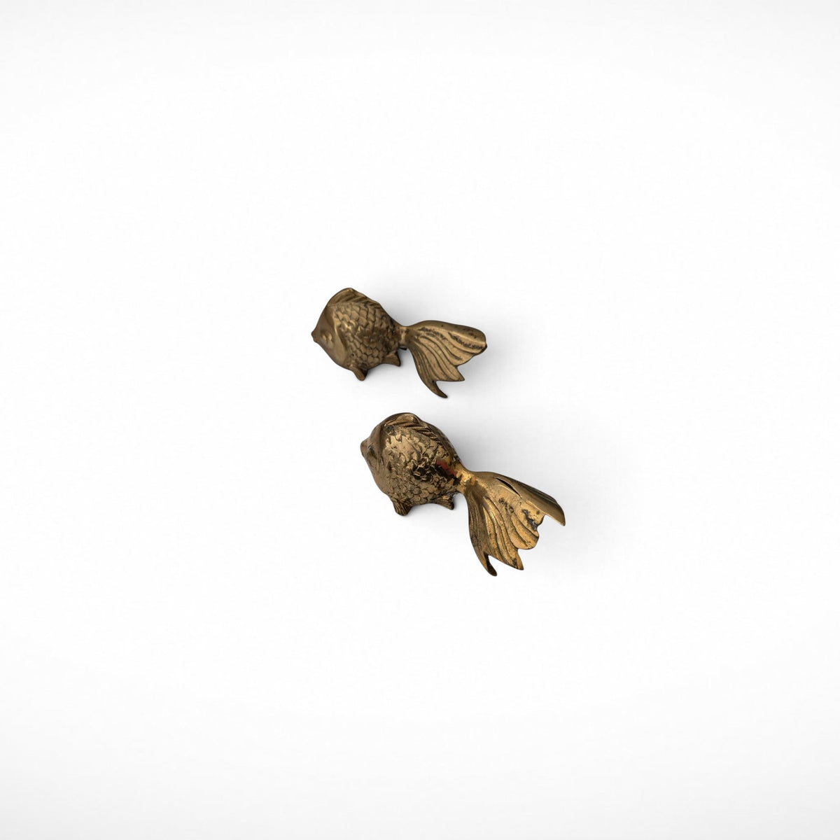 Pair of vintage brass koi fish paperweights, diagonal view from above