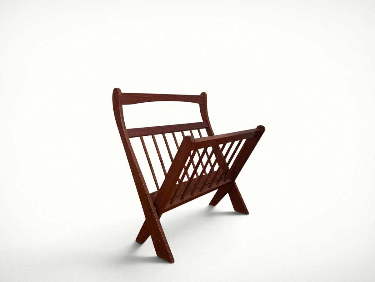 Danish modern folding magazine rack in solid teak, angled view showing spindle panels and X-frame legs