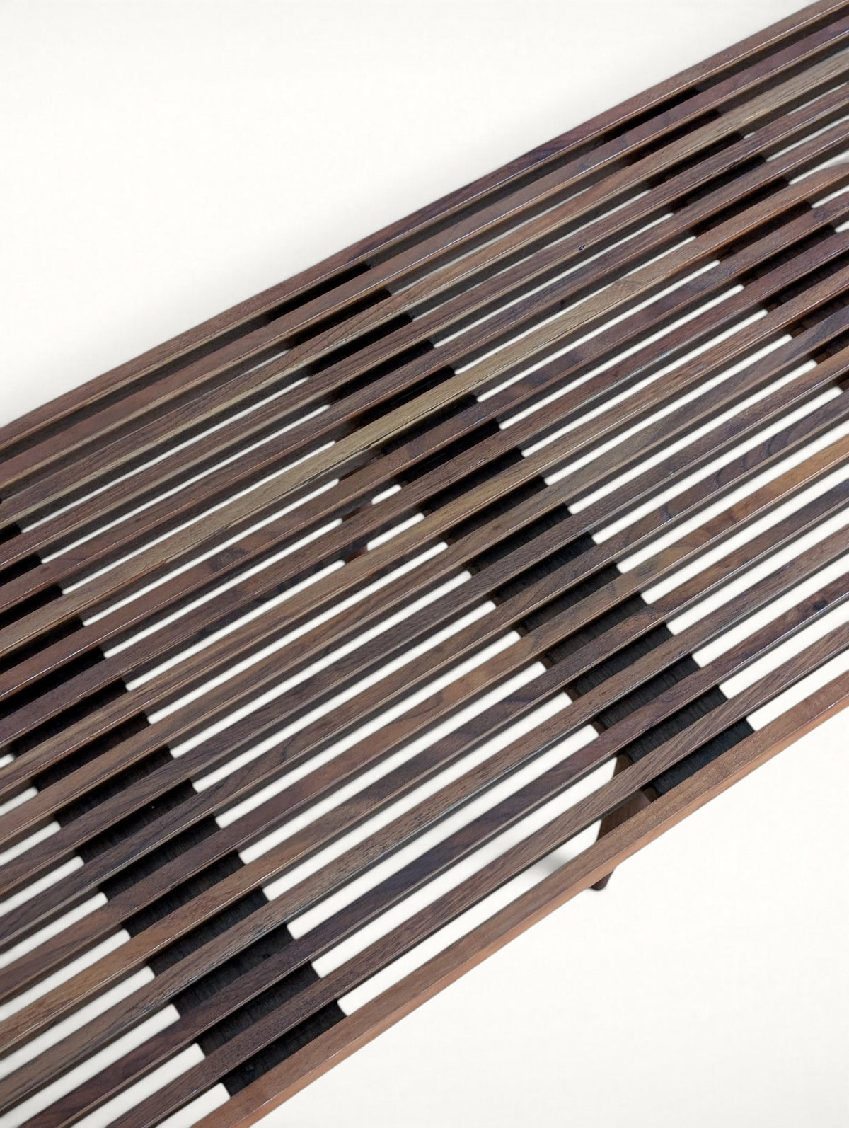 Diagonal close-up of the walnut slats with light wear visible in the grooves