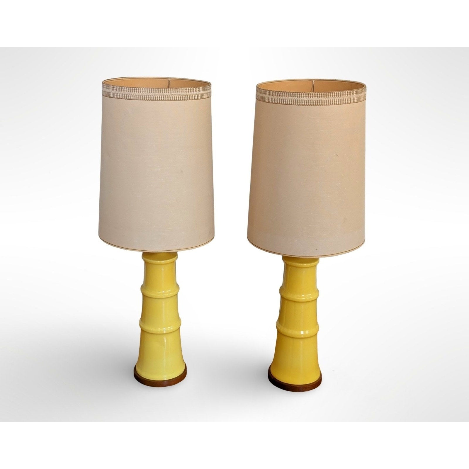 Pair of yellow glazed ceramic table lamps with solid walnut bases and shades in restored mid century modern condition