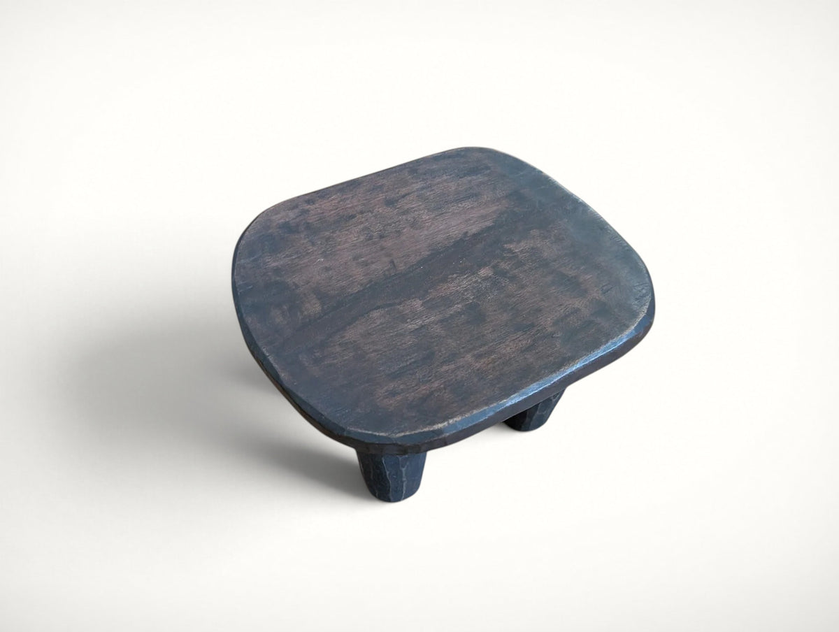 Top view of the Senufo stool's dished seat — dark patina with natural wear from age and use