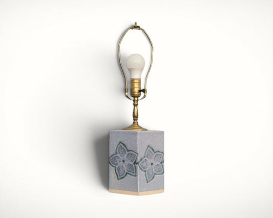 Studio pottery floral ceramic table lamp, front view with bulb and harp